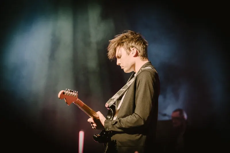 Gitarrist der Winter Lounge im Profil, den Blick auf das Griffbrett der E-Gitarre gerichtet